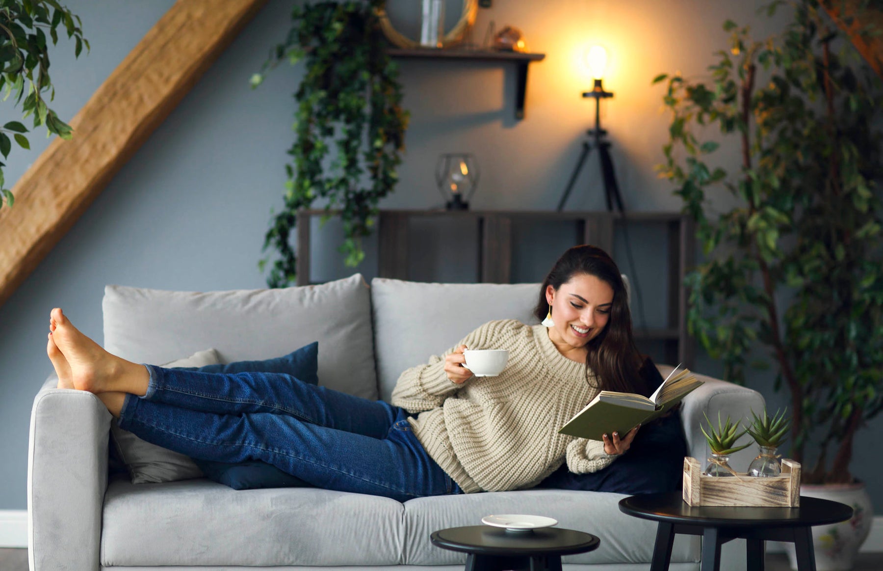 woman relaxing on a couch while reading