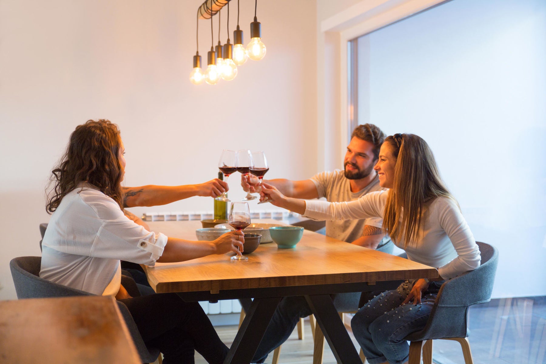two couples having wine in a kitchen with bright lights